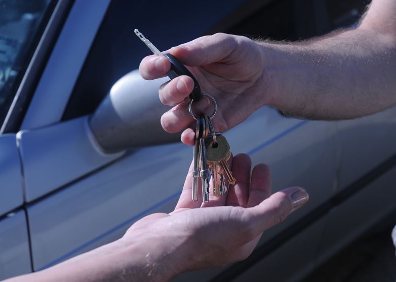 Seller handing car keys to buyer