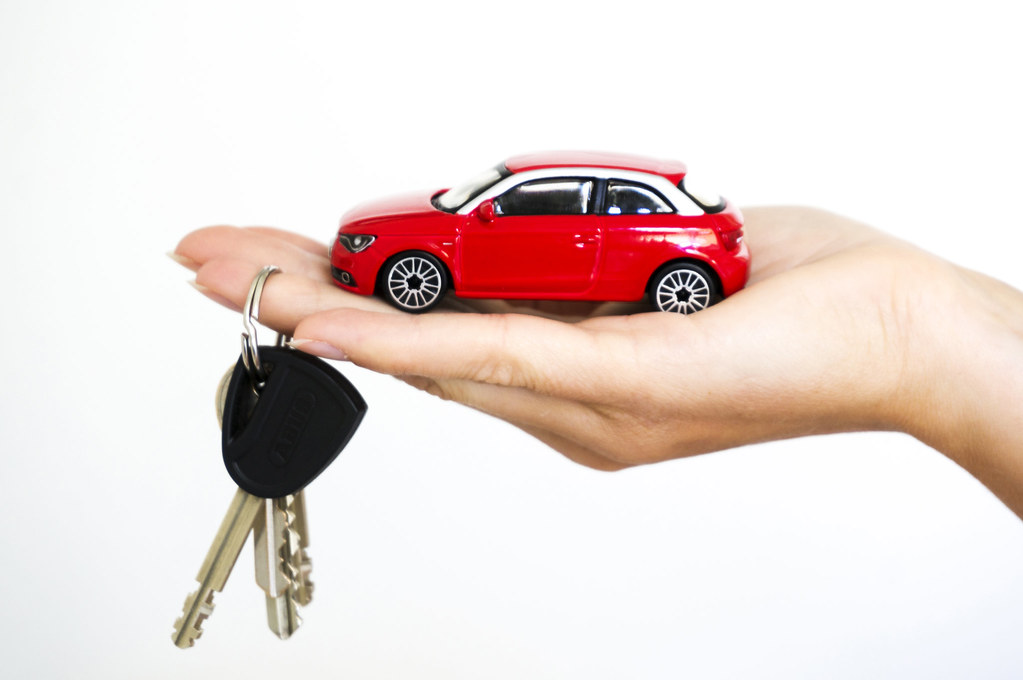 a toy car on the hand with the keys hanging the finger